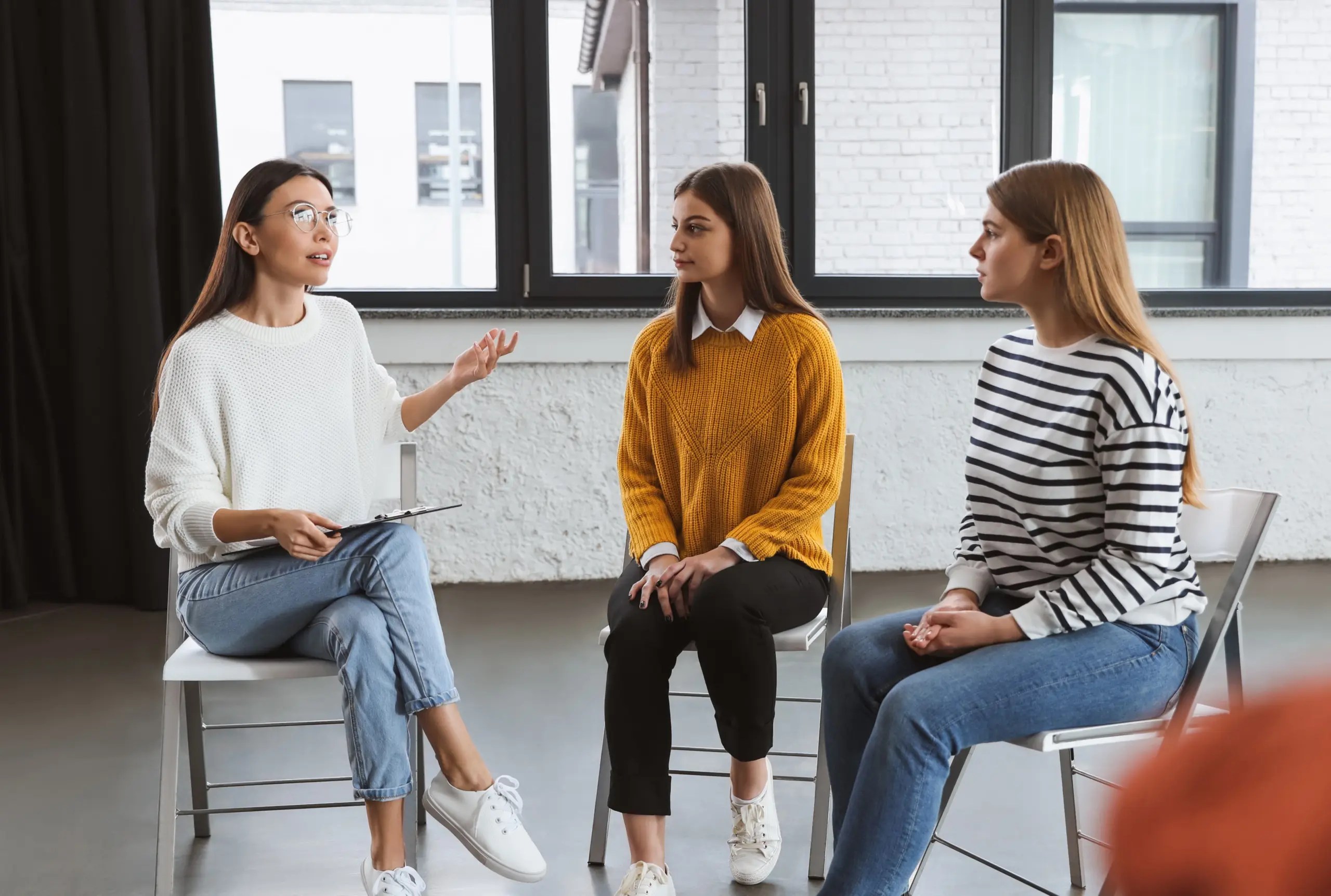 Psychotherapist working with patients in group therapy session indoors